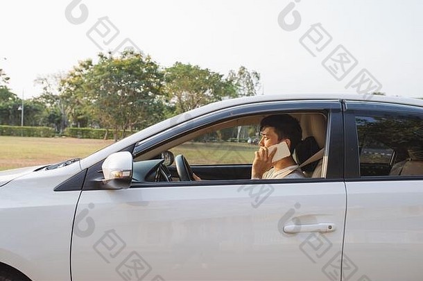微笑男人。说话聪明的电话白色车商人成功的开车车说话手机