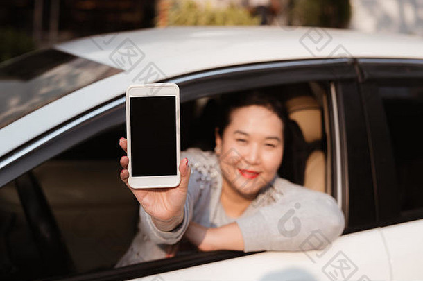 有吸引力的年轻的女人汽车显示智能手机空白屏幕