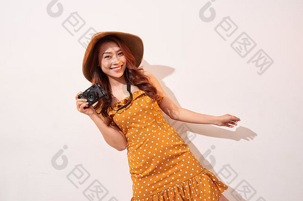 图像年轻的<strong>摄影</strong>师女人孤立的米色背景墙持有相机