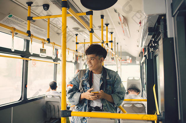 人公共汽车亚洲男人。智能手机公共运输