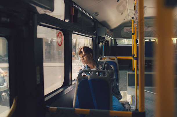 亚洲男人。坐着做梦公共汽车窗口