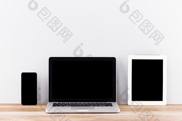 有创意的网络设计机构演讲多个设备电脑显示移动PC平板电脑聪明的电话白色木桌子上砖白色墙