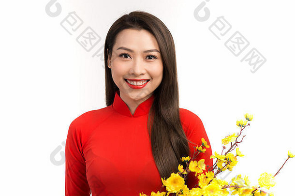 亚洲女人红色的传统的越南衣服持有杏开花花束微笑