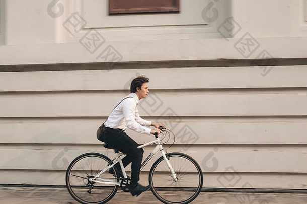 快点亚洲商人骑自行车冲小时年轻的男人。晚些时候火车工作会议办公室生活业务竞争
