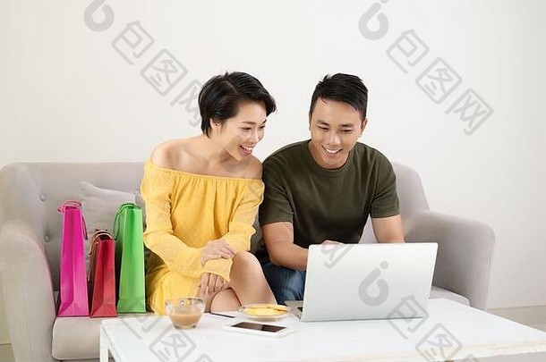 快乐年轻的亚洲夫妇看在线商店移动PC购买首页