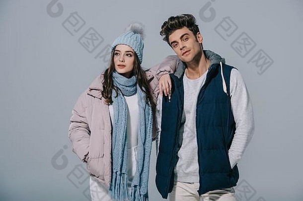 时尚的年轻的夫妇摆姿势冬天装孤立的灰色