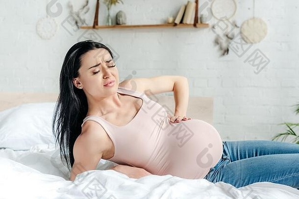 担心怀孕了女人疼痛触碰肚子床上