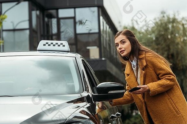 年轻的女人智能手机会说话的出租车司机