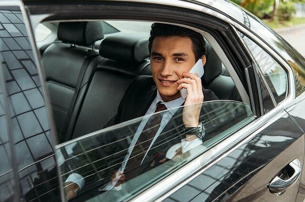 微笑商人会说话的智能手机回来座位出租车