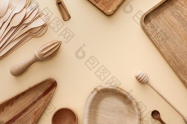 前视图木盘子菜叉勺子手榨汁机米色背景复制空间