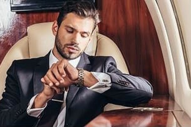全景拍摄英俊的商人西装手表私人飞机