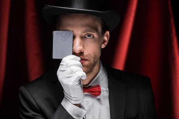 专业魔术师显示技巧玩卡马戏团红色的窗帘