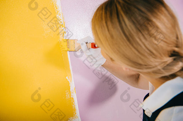 回来视图年轻的画家绘画墙黄色的粉红色的画笔
