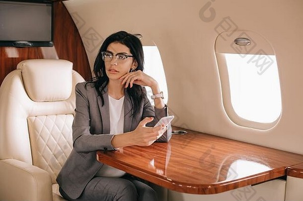 女商人眼镜智能手机私人飞机