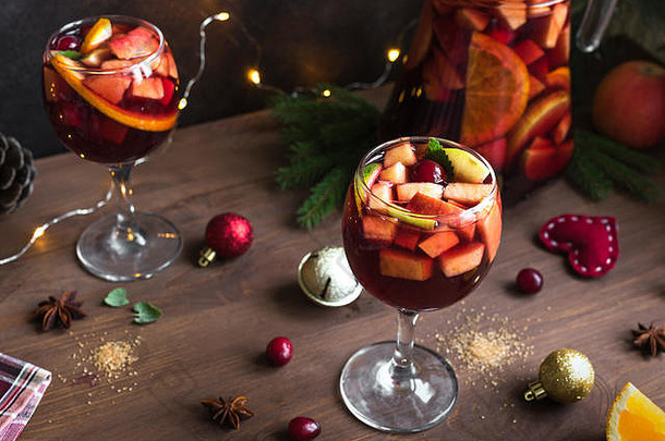 圣诞节sangria穿孔眼镜投手自制的红色的酒水果sangria圣诞节节日装饰木背景复制空间