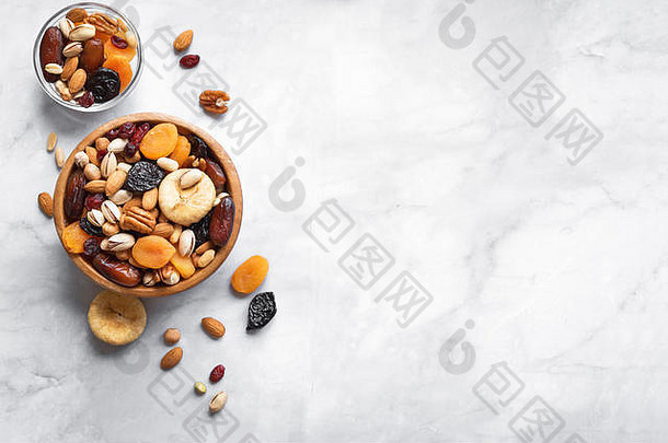 混合坚果干水果木碗白色大理石背景复制空间健康的零食混合有机坚果干水果