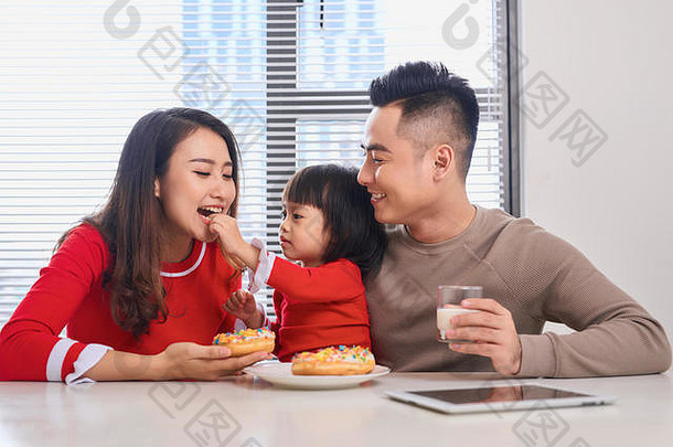 快乐年轻的家庭孩子们享受早餐白色阳光明媚的餐厅房间大花园视图窗口