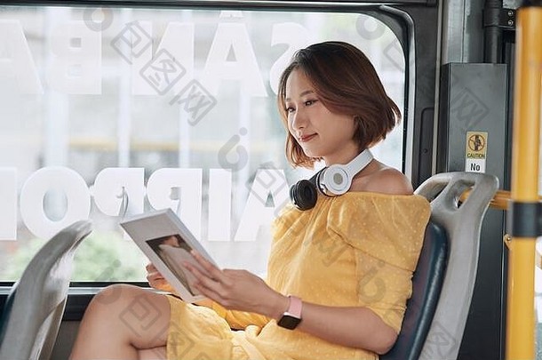 年轻的女人阅读书移动现代有轨电车快乐乘客公共运输