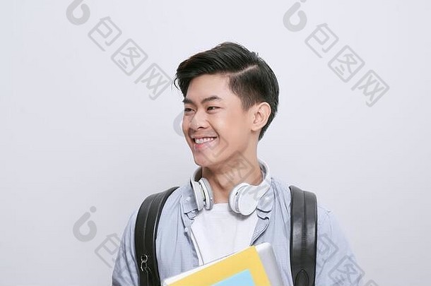 肖像年轻的亚洲学生持有书孤立的白色背景
