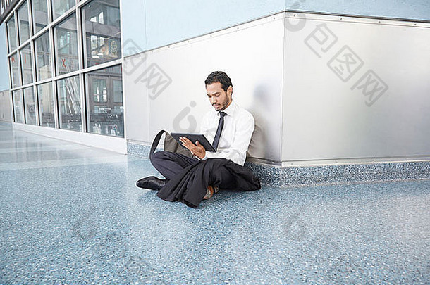 商人坐着地板上数字平板电脑