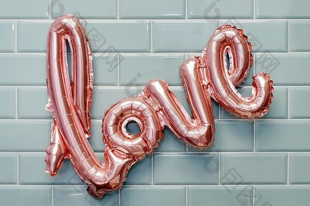 爱词粉红色的充气气球薄荷瓷砖墙背景概念浪漫情人节一天爱玫瑰黄金箔气球