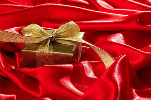 圣诞节礼物金礼物盒子黄金丝带红色的缎背景横幅复制空间