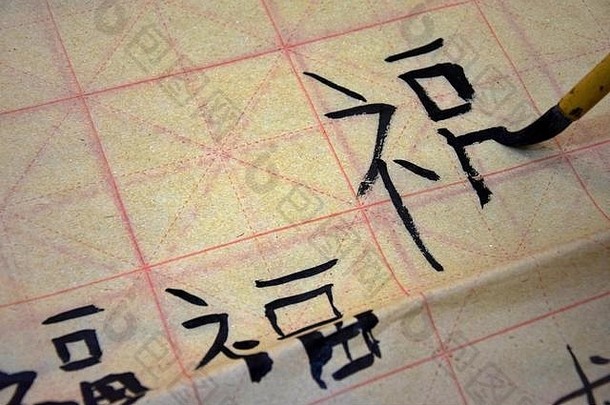 手持有画笔写作中国人字符幸福练习<strong>书法培训</strong>表脆弱的纸