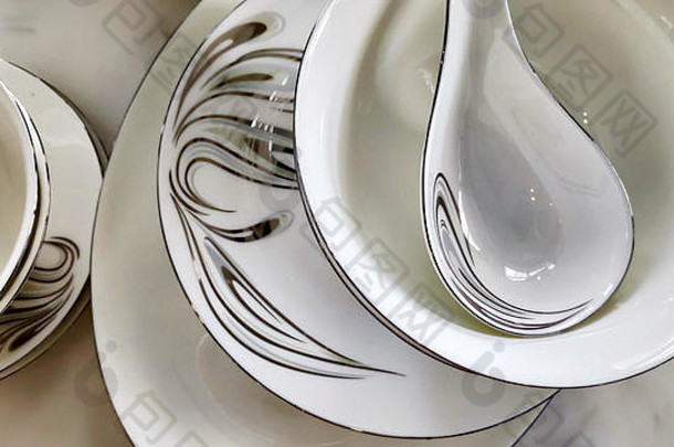 堆栈陶瓷盘子碗勺子中国瓷优雅的白色灰色装饰花模式古董餐具白色表格