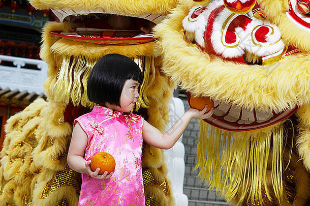 女孩持有普通话橙子摆姿势盈方狮子舞者