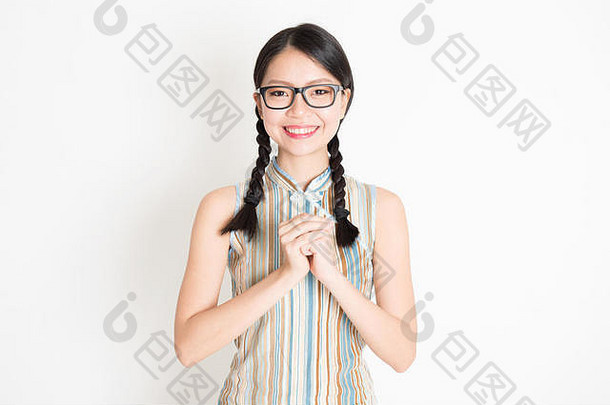 肖像年轻的亚洲女孩传统的旗袍衣服问候庆祝中国人月球一年春天节日站平原背景