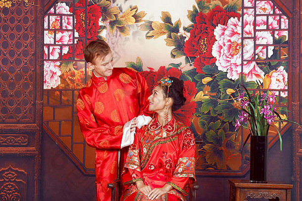 混合比赛新娘新郎工作室穿传统的中国人婚礼服装