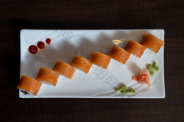 新鲜的大马哈鱼前漂亮的提出了寿司卷白色板