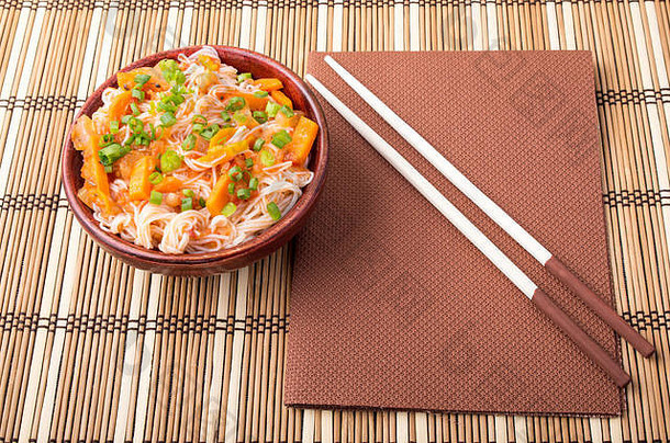 前视图亚洲碗大米面条蔬菜调味料小木碗条纹席