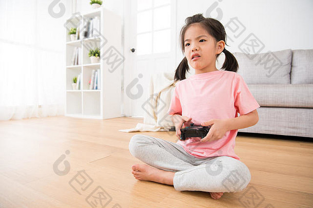 甜蜜的女孩孩子孩子们显示伤心不开心表达式坐着木地板上操纵杆玩视频游戏首页