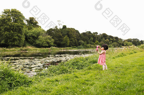 蹒跚学步的女孩玩探索阳光明媚的夏天农村北部爱尔兰