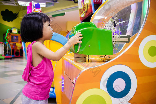 亚洲中国人女孩玩商场游戏机室内娱乐操场上