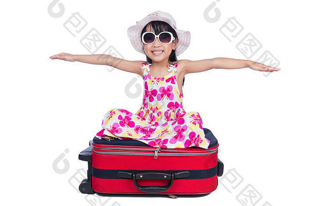 快乐亚洲中国人女孩坐着手提箱孤立的白色背景