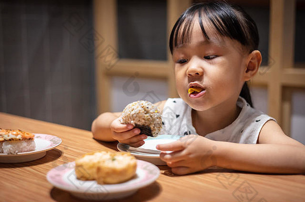 亚洲中国人女孩吃大米球日本餐厅