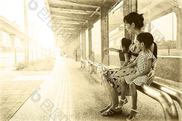 亚洲中国人妈妈。女儿等待公共汽车公共汽车停止