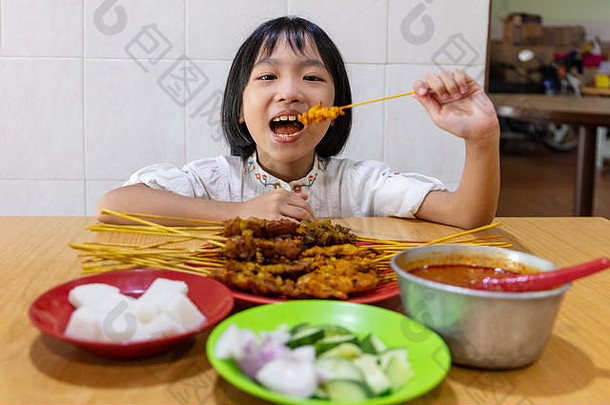 亚洲中国人女孩吃沙爹室内餐厅