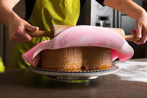 关闭女人面包店装修心形状的蛋糕粉红色的皇家糖衣