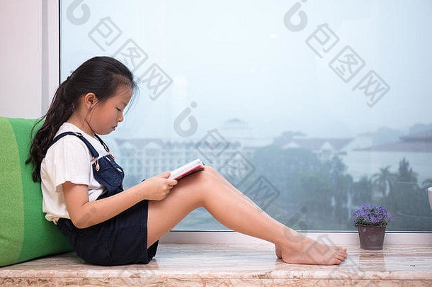亚洲中国人女孩阅读书窗台上首页