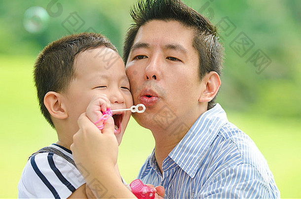亚洲父亲玩孩子肥皂泡沫