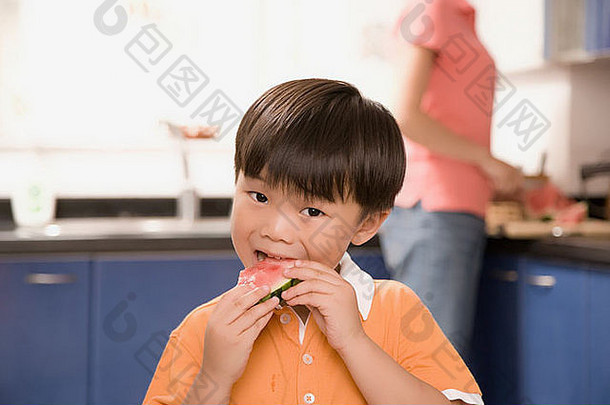 特写镜头男孩吃西瓜妈妈。站