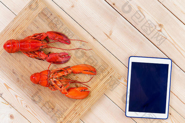 红色的龙虾准备好了烹饪竹子董事会与空白平板电脑Copyspace木厨房表格开销