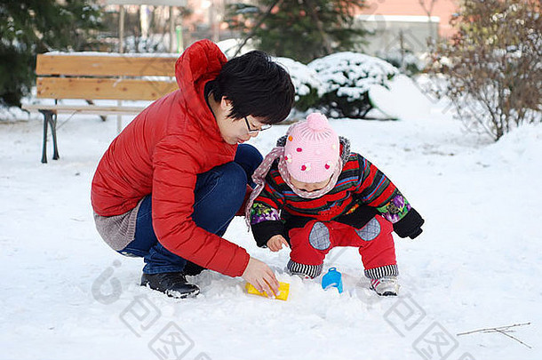 中国人妈妈。婴儿玩雪