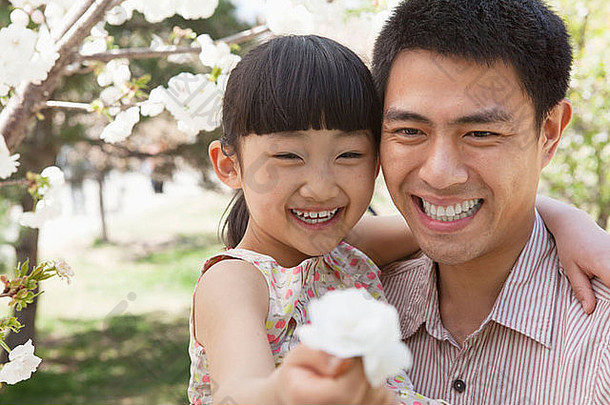 微笑父亲女儿享受樱桃花朵树公园春天女儿持有花
