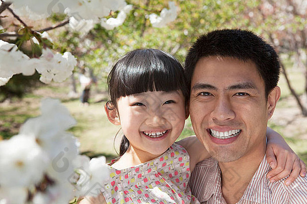 微笑父亲女儿享受樱桃花朵树公园春天肖像