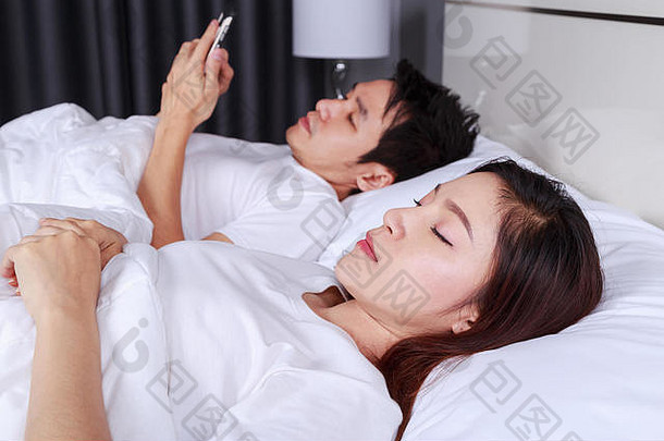 女人床上睡觉丈夫发短信智能手机卧室