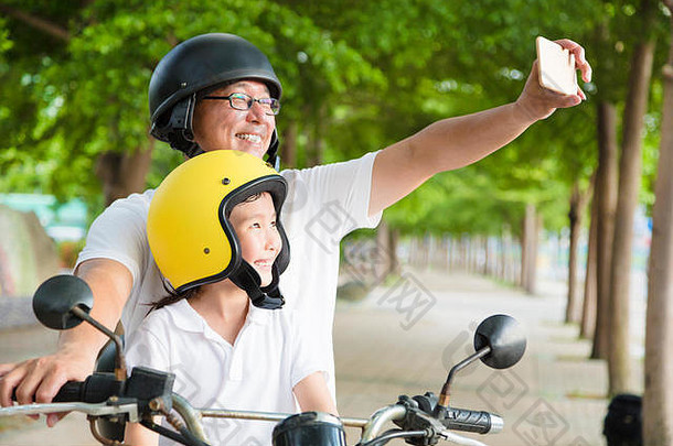 父亲女儿旅行采取自拍摩托车